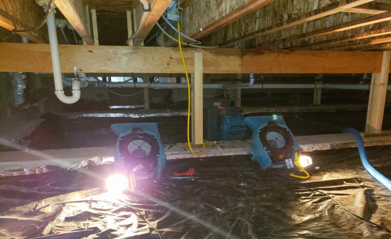 A crawl space with air mover to dry out the structure.
